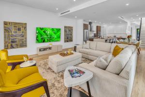 フォート・ローダーデールにあるTownhouse Heated Pool Centrally Located Malibu Keyのリビングルーム(黄色の椅子、白いソファ付)