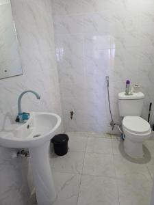 Cozy Breeze Apartment في مومباسا: حمام أبيض مع مرحاض ومغسلة +14 صورة