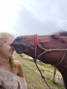 a woman is kissing a brown horse at Garden de Arts in Pai