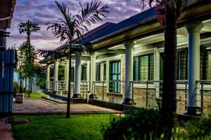 a building with a palm tree in front of it at Stay simple lodge in Lusaka
