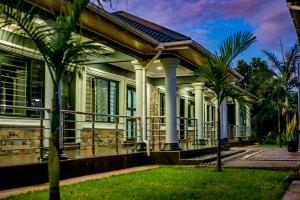 una casa con delle palme davanti di Stay simple lodge a Lusaka