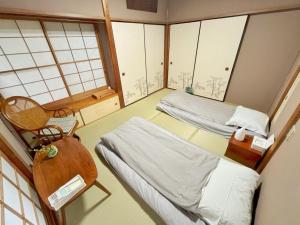 a room with two beds and a chair in it at Japan Harry Potter 5min Walk Guesthouse 東京ハリーポッターまで徒歩5分の民宿 in Tokyo