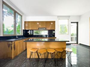 Nhơn TrạchにあるLumiere Villa Swanbayのキッチン(カウンター、4脚のスツール付)