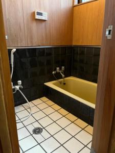 a bathroom with a yellow tub and a tiled floor at Japan Harry Potter 5min Walk Guesthouse 東京ハリーポッターまで徒歩5分の民宿 in Tokyo +30 photos