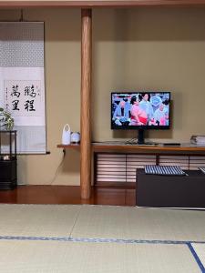 a living room with a flat screen tv on a shelf at Japan Harry Potter 5min Walk Guesthouse 東京ハリーポッターまで徒歩5分の民宿 in Tokyo