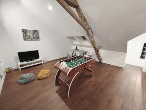 a living room with a table and a tv at Maison Loire & Cé'rénité in Les Ponts-de-Cé