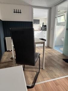 a black chair sitting next to a table in a kitchen at Apartment Heidchen in Knüllwald