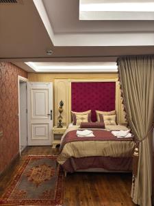 Un dormitorio con una cama grande con cabecero rojo. en Sultan Suites Hotel, en Estambul