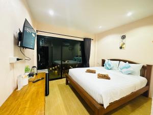 a bedroom with a large bed with a tv at Family House Resort, Haad Rin in Haad Rin