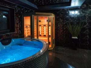 a jacuzzi tub in a room with a door at Villa in Nowy Targ with Mountain Views & Pool in Nowy Targ