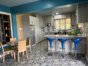 a kitchen with a island with blue stools in it at Tranquil 3 Bedroom - Lonely Hill Apartment in Honiara