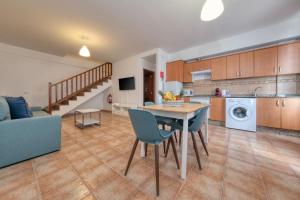 Una cocina y una sala de estar con mesa y sillas. en Mar y Ola, en Playa Blanca