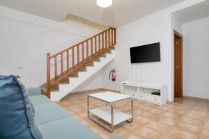 Una sala de estar con un sofá y un televisor. en Mar y Ola, en Playa Blanca