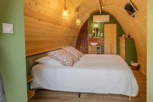 a bedroom with a white bed in a wooden room at Chambre d'Hôtes La Guignette in Saint-Cybranet