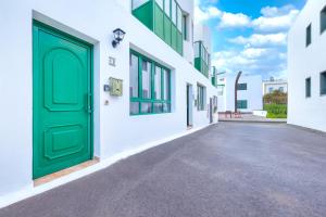 una puerta verde en el costado de un edificio en Mar y Ola, en Playa Blanca