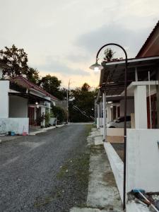 an empty street with a street light next to houses at Homestay Tata in Bugisan