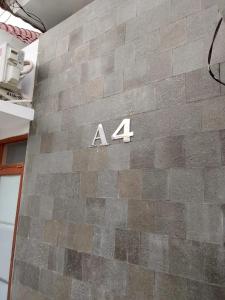 sign on the side of a brick wall at Homestay Tata in Bugisan