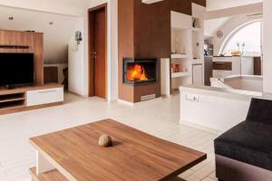 a living room with a fireplace in the middle at Apartment Mountain Sunrise in Škofja Loka