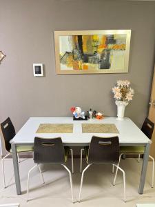 a dining room table with chairs and a vase of flowers at 望月ハウス101 in Tokyo