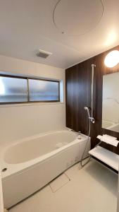 a bathroom with a white tub and a window at 望月ハウス101 in Tokyo