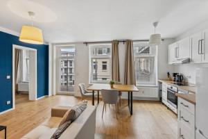une cuisine et un salon avec une table et des chaises dans l'établissement Erholsame Wohnung mit Balkon und Einbauküche im Herzen Leipzigs, à Leipzig