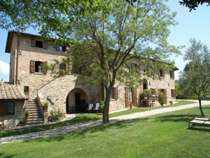 a large stone building with a tree in the yard at Holiday Home in Montone with Pool & Terrace in Montone