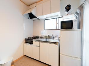 a small kitchen with a sink and a refrigerator at Ikebukuro-Otsuka-10min ShinOtsuka Sta-For families and groups-Switch-net-Mobile Wi-Fi in Tokyo +43 photos