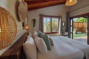 a bedroom with a large bed with pillows at בקתות לואיז in Had Nes