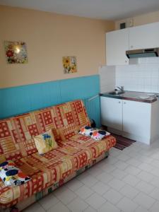 a living room with a couch in a kitchen at studio cabine avec loggia Cap d Agde in Cap d'Agde