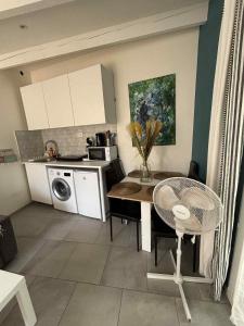 a kitchen with a table and a kitchen with a microwave at M 10 maison avec spa et jardin proche de la mer in Marseille +3 photos