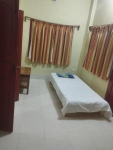 mayapurにあるKrishna Divine 2 Bedroom Homeのベッドと2つの窓がある寝室