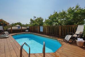 a swimming pool on a deck with a wooden fence at בקתות לואיז in Had Nes