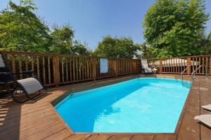 a swimming pool on a deck with a fence at בקתות לואיז in Had Nes +23 photos