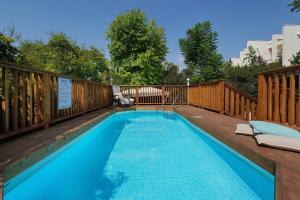 a swimming pool on a deck with a wooden fence at בקתות לואיז in Had Nes