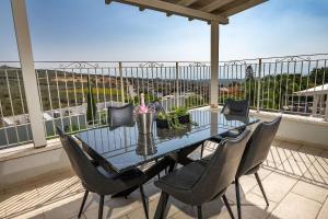 a glass table and chairs on a balcony at Villa siena - וילה מהממת עם בריכה פרטית מול הכנרת in Migdal