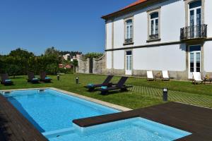 a swimming pool in the yard of a house at Solar Egas Moniz-Charming House & Local Experiences in Paço de Sousa