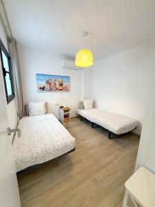 ein Zimmer mit 2 Betten und einer Hängeleuchte in der Unterkunft Arguineguín, pueblo pesquero in Arguineguín