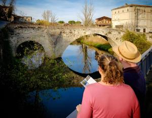 two people looking at the water under a bridge at T2 Cosy, agréable fonctionnel et douillet, 1 lit 140 et un BZ , Wifi gratuit, boîte à clés, proche commerces et gare routière, linge de lit et toilette offerts à partir de 4 nuits in Graulhet