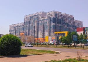 duży budynek z samochodem jadącym drogą w obiekcie Апартаменты рядом с Хан-Шатыром, на левом берегу w mieście Astana