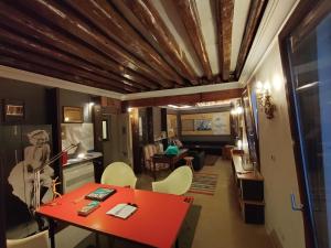 sala de estar con mesa roja y sillas en Suite Apartment San Marco 1825, en Venecia