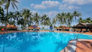a large swimming pool with palm trees in the background at Saigon Phu Quoc Resort & Spa in Phu Quoc