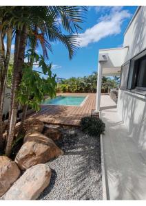a backyard with a swimming pool and a wooden walkway at Villa Emeraude in Saint-Louis