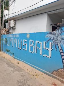 un muro blu con la scritta Mimosa Bay dipinta sopra di Hummus Bay Arugam ad Arugam