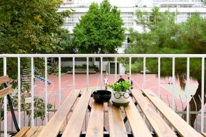 テッサロニキにあるThessaloniki Downtown Comfort 1 Apartmentの木製ベンチ(鉢植えの植物付)