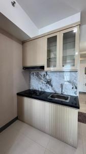 una cucina con un lavello e un piano di lavoro di Anderson Benson Pakuwon mall Daily by Sty a Surabaya