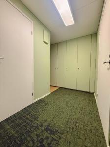 an empty room with white cabinets and a rug at Ellis Seaside Suite in Helsinki