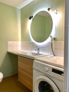 a bathroom with a washing machine and a mirror at Ellis Seaside Suite in Helsinki