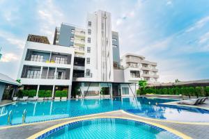 a swimming pool in front of a building at Shewin de Bangkok in Ban Bang Bamru