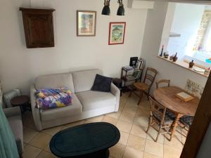 a living room with a couch and a table at Maison Normande in Saint-Michel-de-la-Pierre