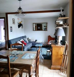 a living room with a table and a couch at 90 m2, 3 chambres, coeur de village, 10 mns des pistes, navette gratuite in Bolquere Pyrenees 2000